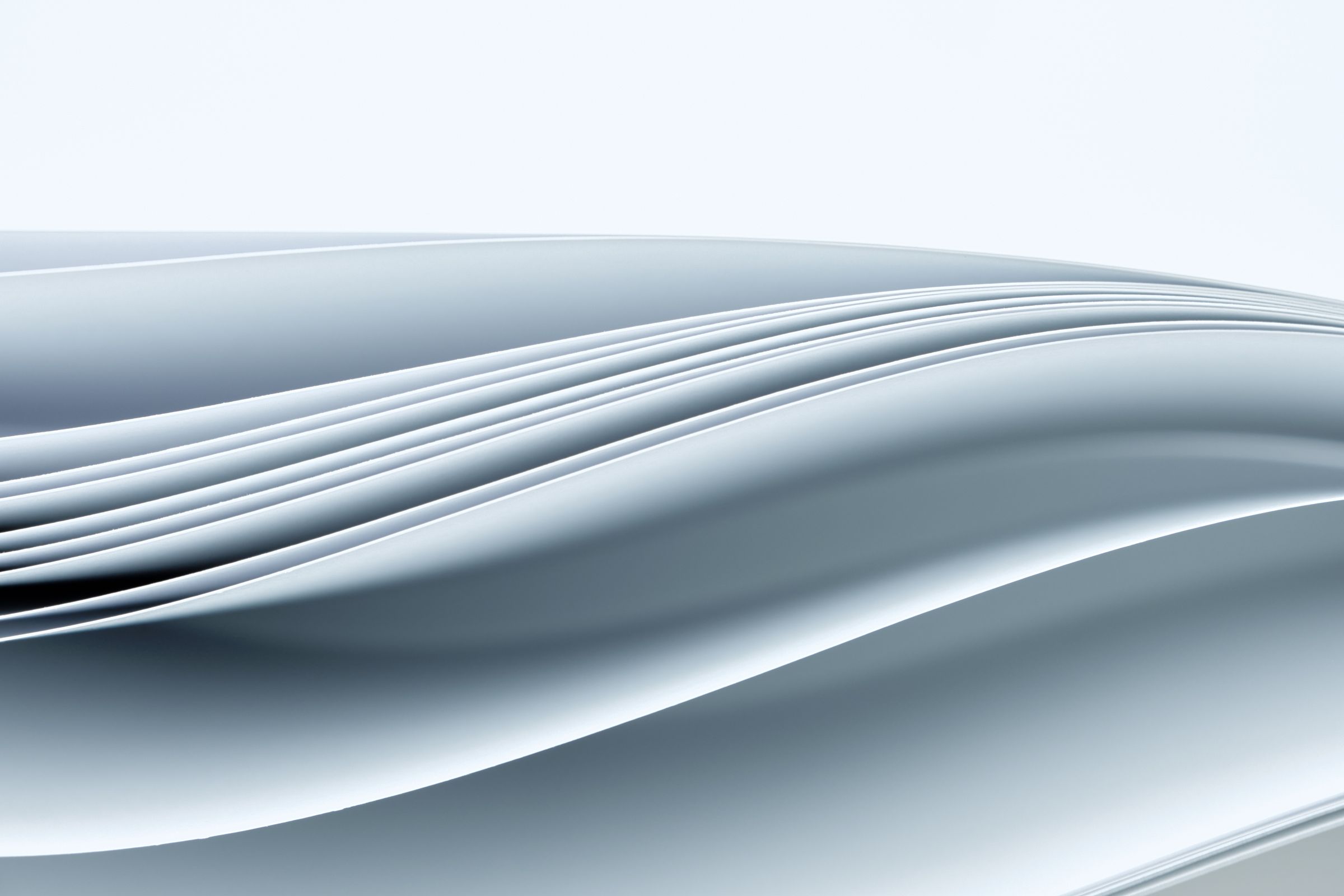 Sheets of white paper curving into a soft wave