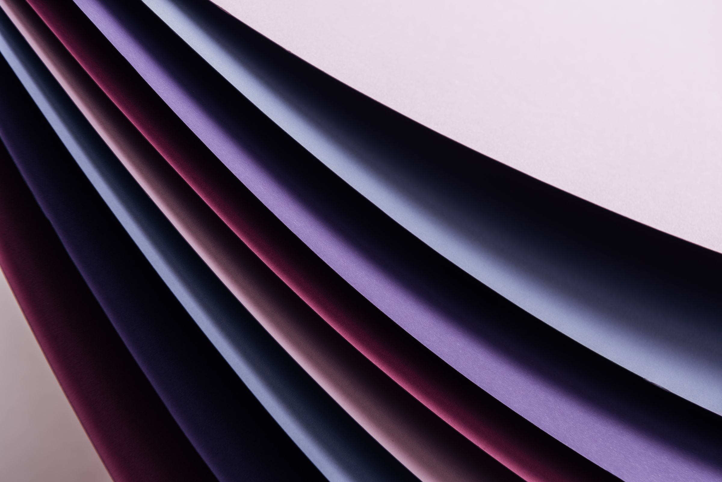 Sheets of white, pink and violet curving in layers