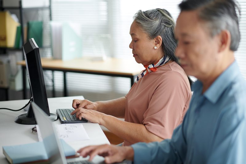 Two colleagues working through a task together at a computer